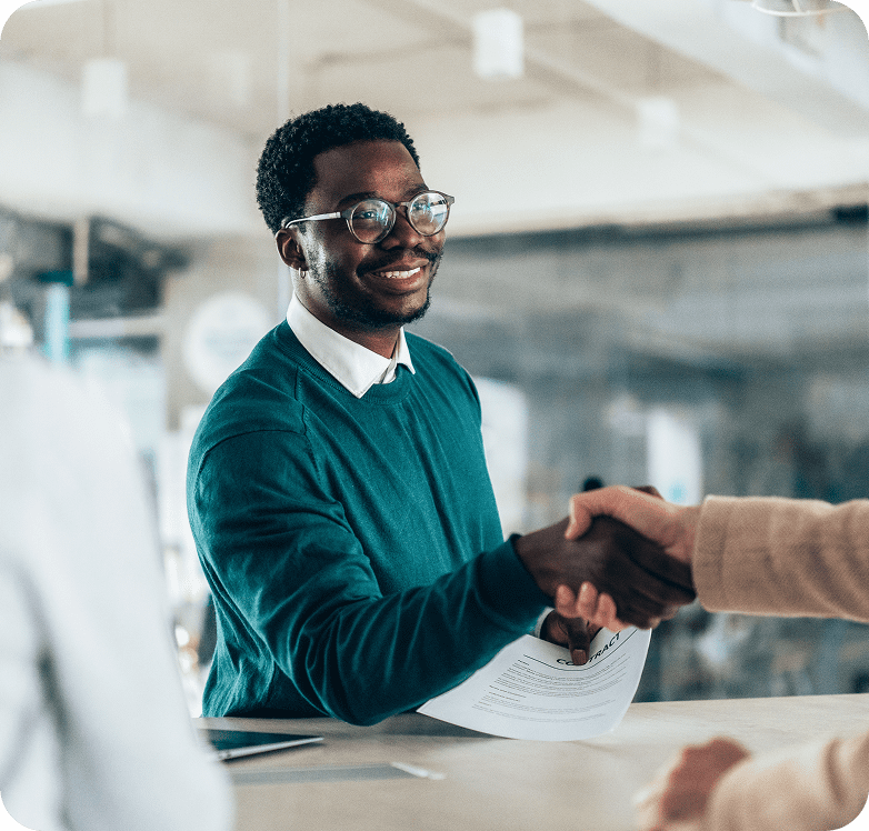 Man in glasses smiling, shaking hands.